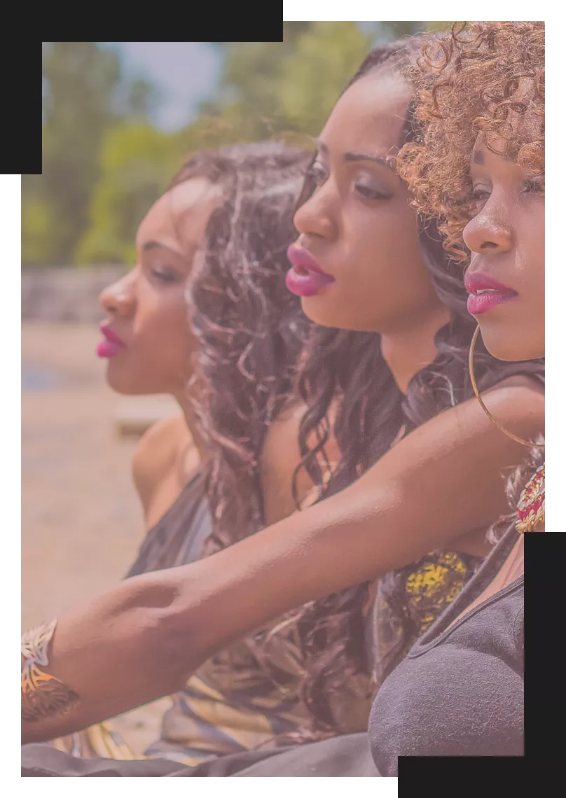 Three black woman sitting beside each other and staring off into the distance.